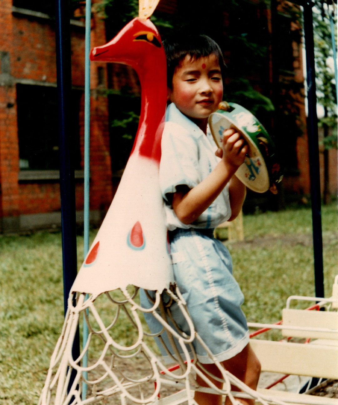 1983年，4岁的谭恩身后是当时住的“筒子楼”